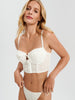 Woman wearing a white lace bikini against a plain background
