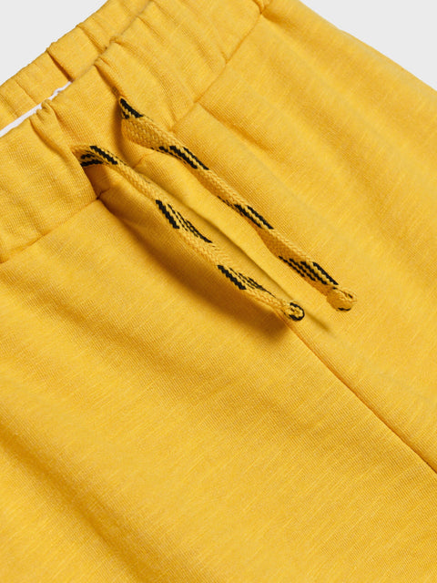 Close-up of yellow pants with drawstrings on a white background