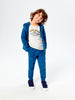 Child wearing a blue tracksuit with a white shirt on a white background