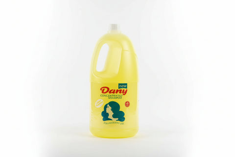 Yellow bottle of Dany concentrated shampoo on a concrete floor.