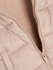 Close-up of a beige quilted jacket with a zipper