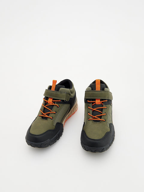 Pair of green and black shoes with orange laces on a white background