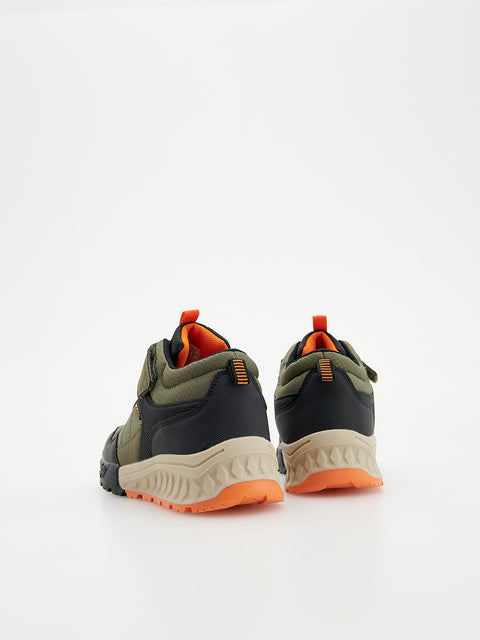 Pair of green and black shoes with orange accents on a white background
