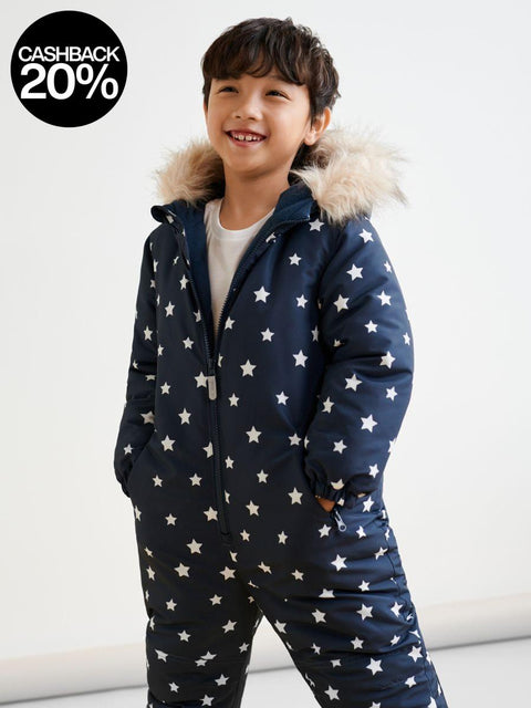 Child wearing a navy blue snowsuit with white star pattern and fur-lined hood on a white background