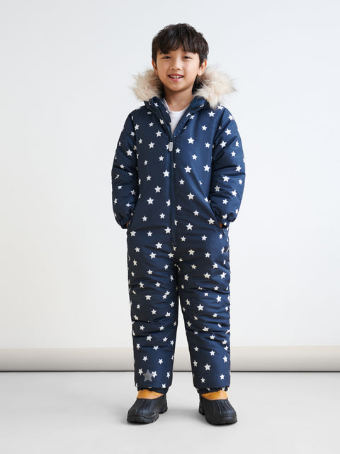Child wearing a navy blue snowsuit with white star pattern on a white background