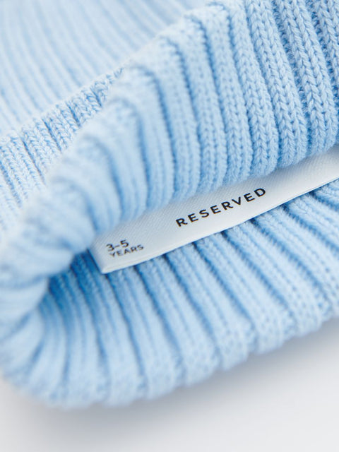 Light blue knitted fabric with a 'RESERVED' tag on a white background