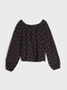Black blouse with red floral pattern on a light gray background