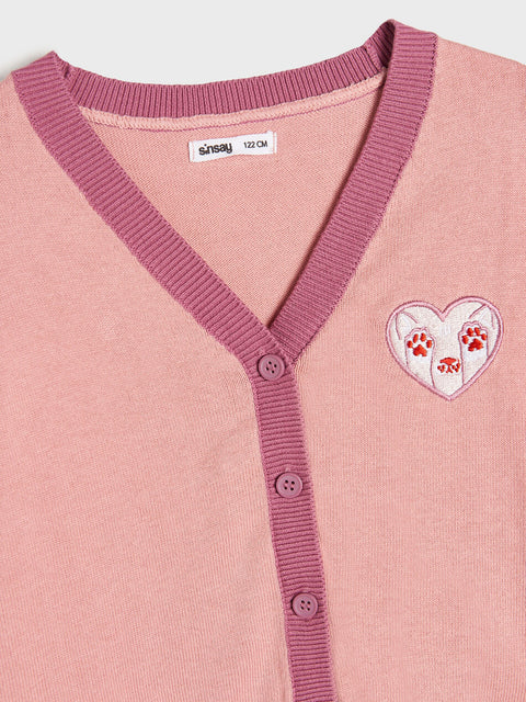 Pink cardigan with a heart design featuring paw prints on a light gray background