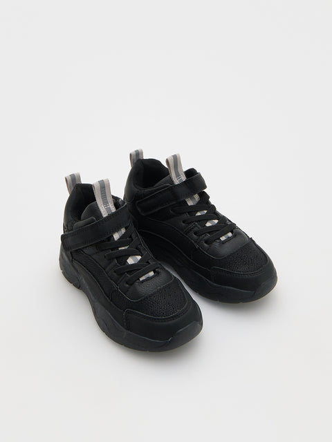 Pair of black sneakers with velcro straps on a white background
