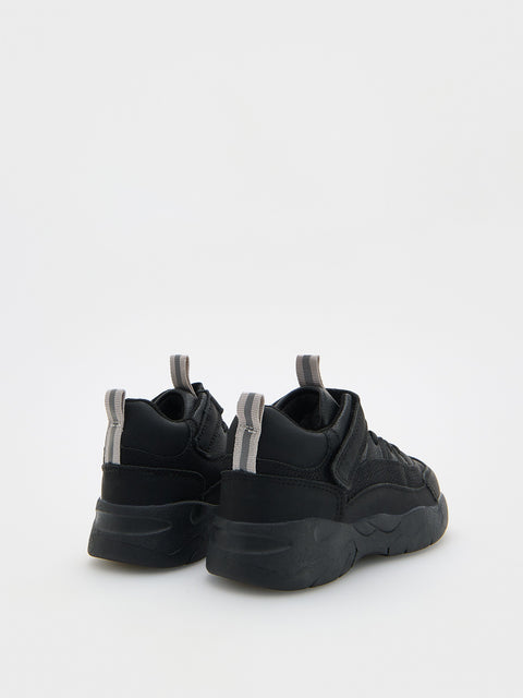 Black sneakers with thick soles on a white background