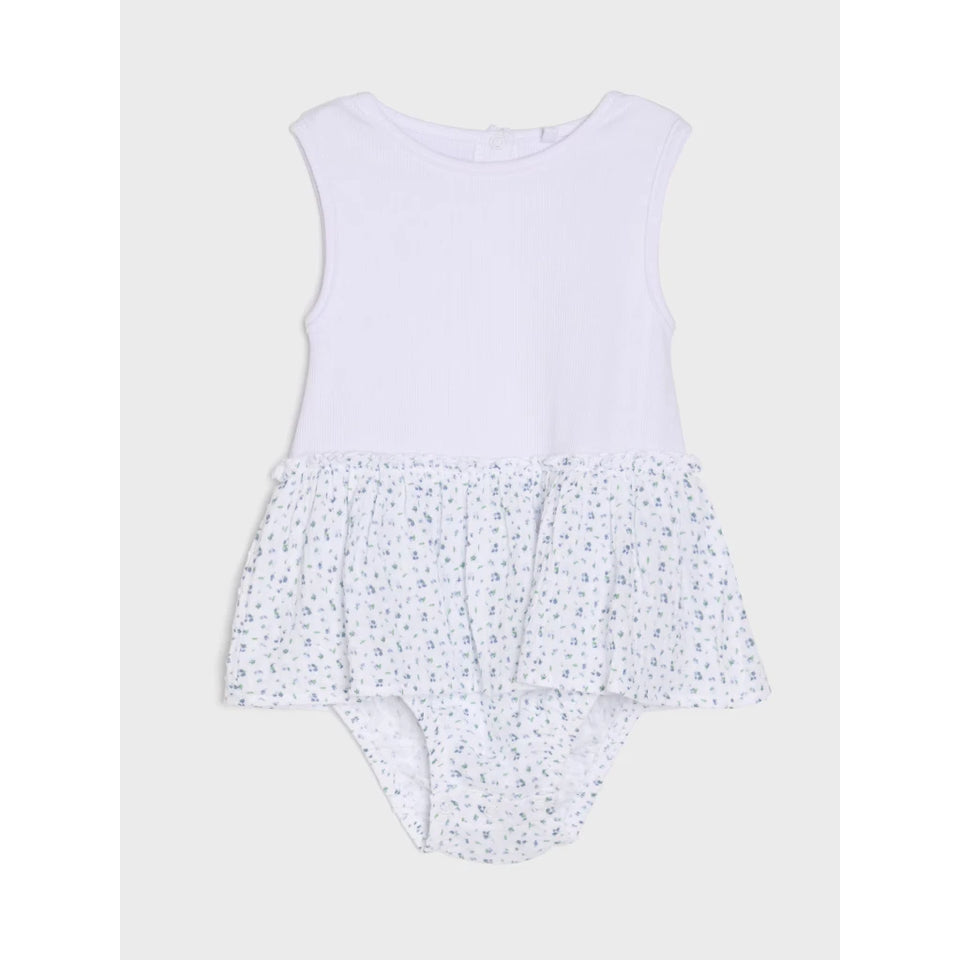 A baby girl's sleeveless romper in white, featuring a solid white top half and a ruffled, white fabric bottom half with a small blue floral print.