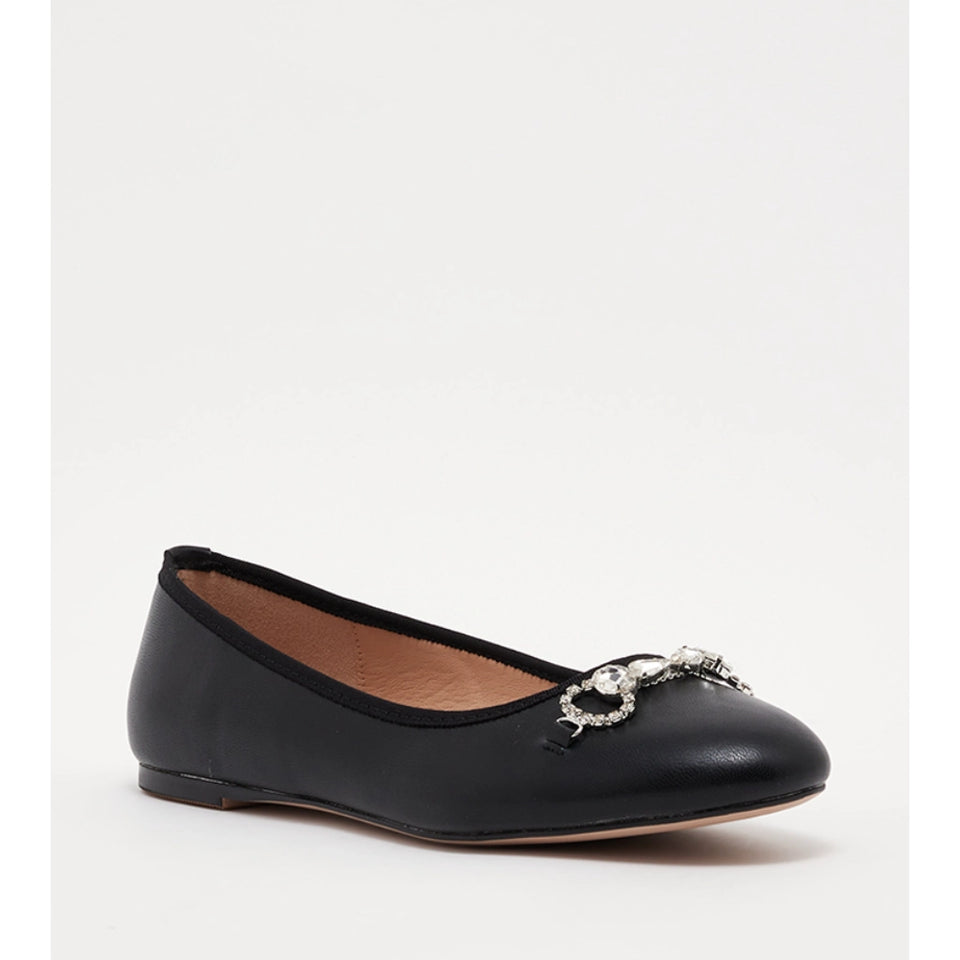 A black leather ballet flat shoe with a pointed toe and a decorative silver-tone metal and crystal embellishment on the vamp, shown against a plain light gray background.