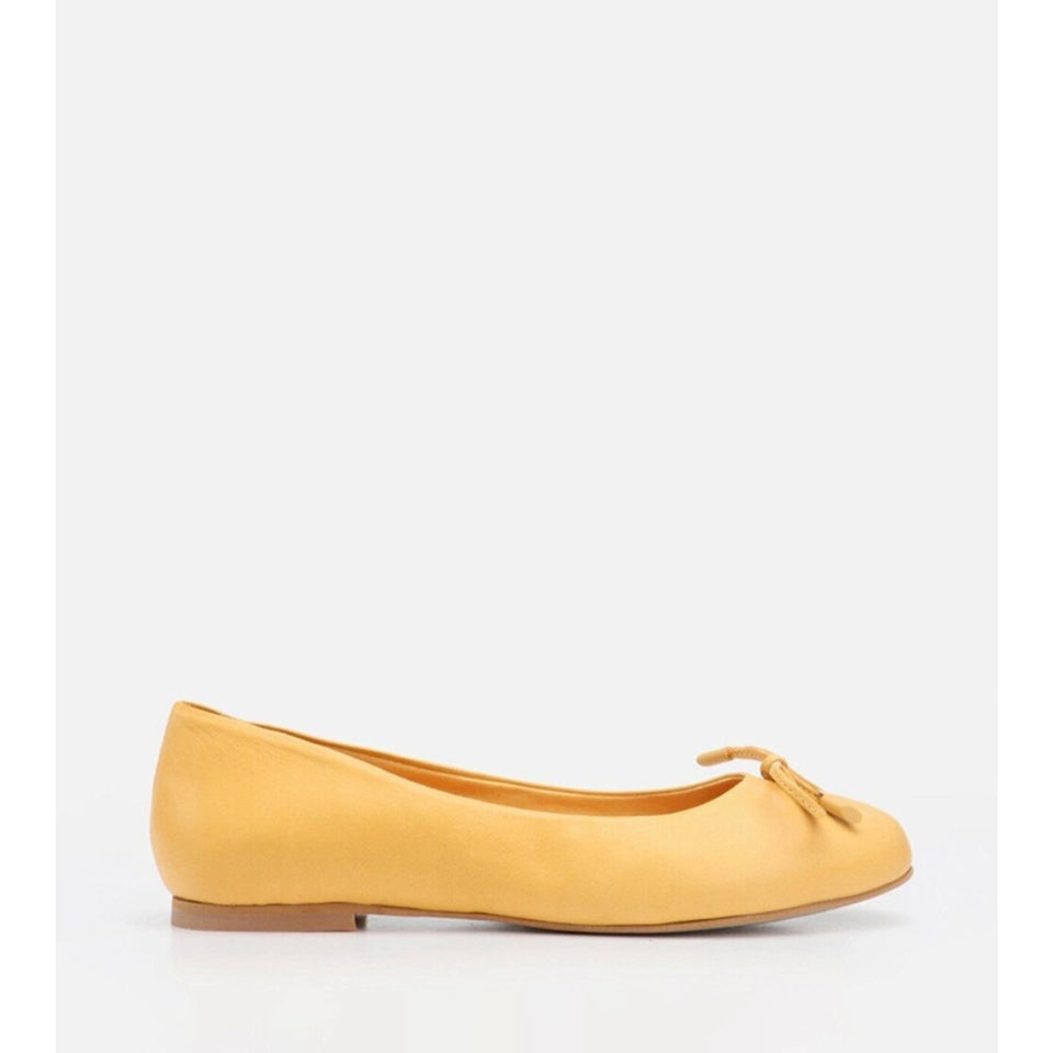 A single yellow suede ballet flat shoe with a small bow detail on the toe, shown in profile against a plain white background.