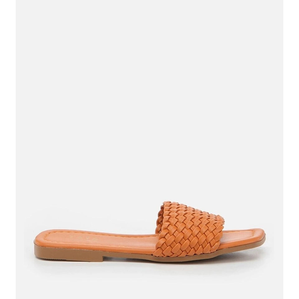 A single flat slide sandal with a woven tan leather strap and a matching tan footbed, shown in profile against a light gray background.