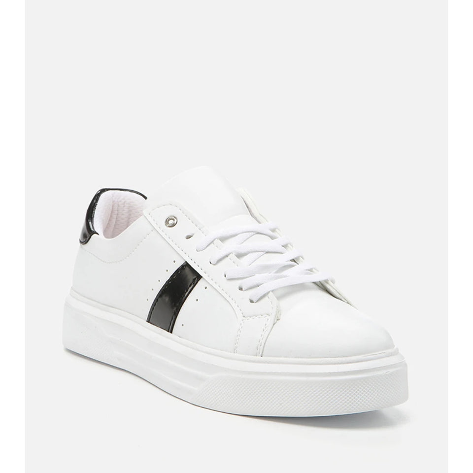 A white low-top platform sneaker with a glossy black side stripe, white laces, and a chunky white sole, shown from a three-quarters angle on a light gray background.