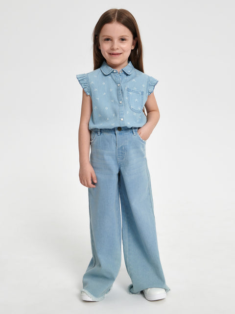 Young girl wearing a light blue denim outfit on a white background