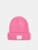 Pink beanie with a small white label on a light gray background