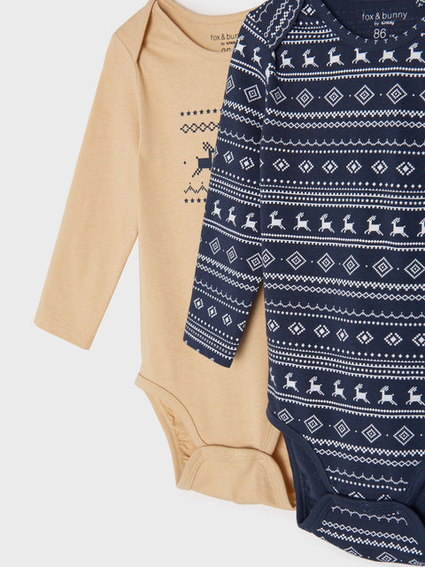 Beige and navy baby onesies with patterns on a light gray background