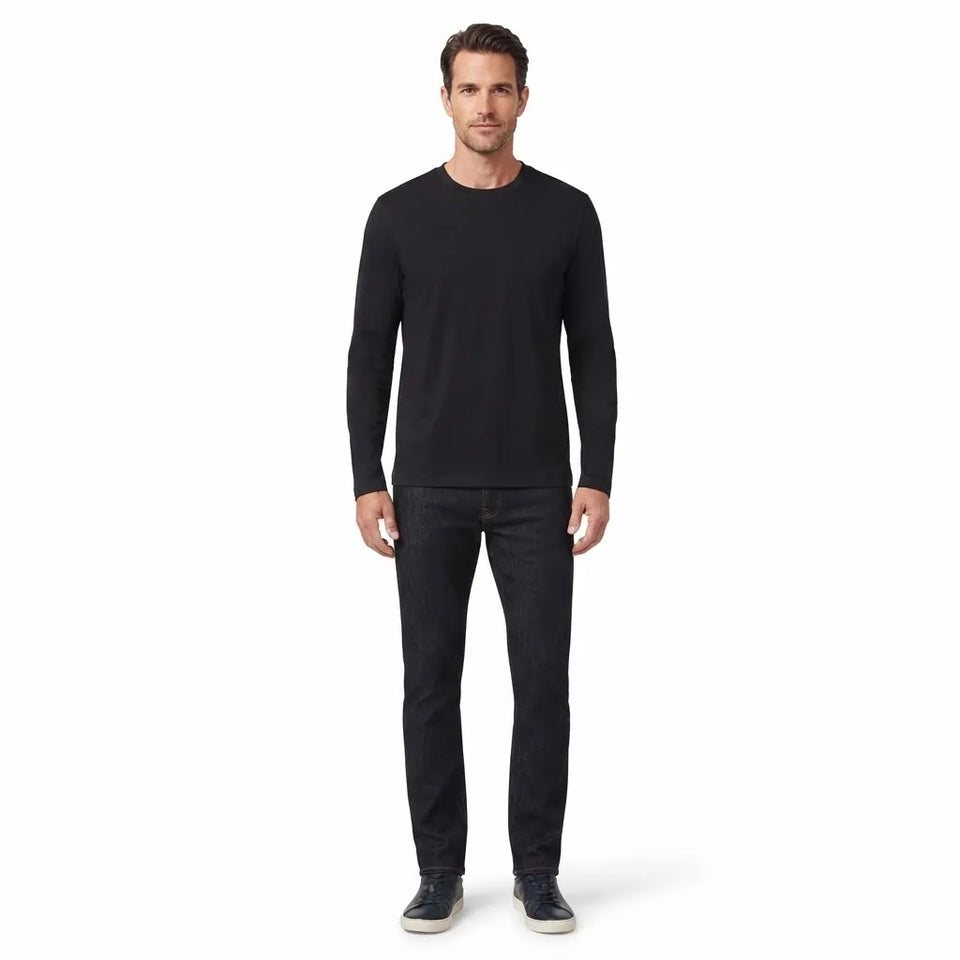 A man modeling a black long-sleeve crewneck shirt and dark charcoal jeans against a plain white background.