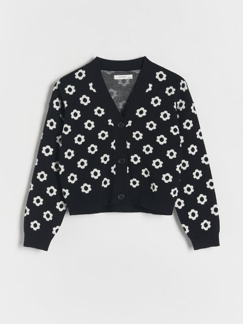 Black cardigan with white floral pattern on a light gray background