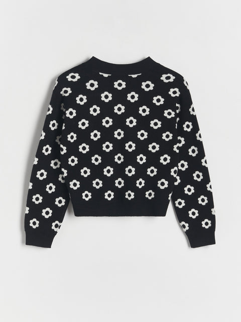 Black sweater with white floral pattern on a light gray background