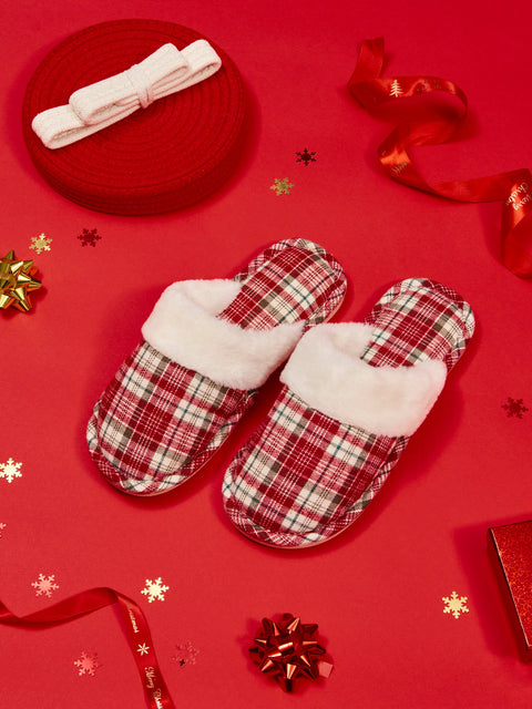Plaid slippers with white fur lining on a red background with decorative elements.
