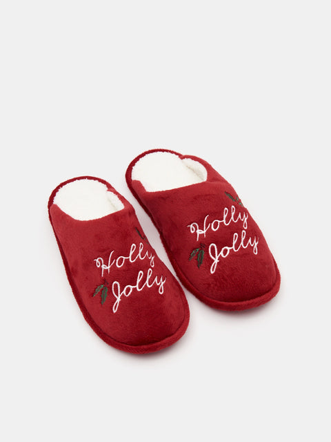 Red slippers with 'Holly Jolly' text on a white background