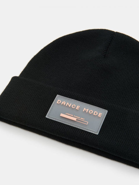 Black beanie with 'DANCE MODE' label on a light gray background