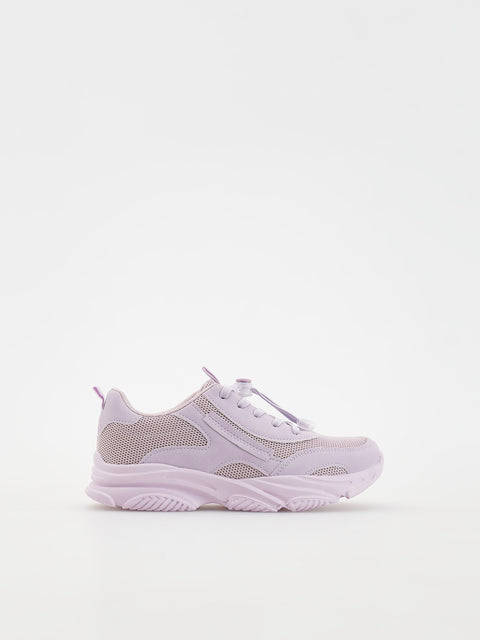 White sneaker with mesh design on a light gray background