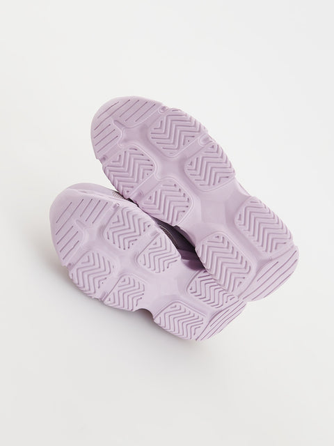 Pair of lavender slides with textured sole on a light purple background