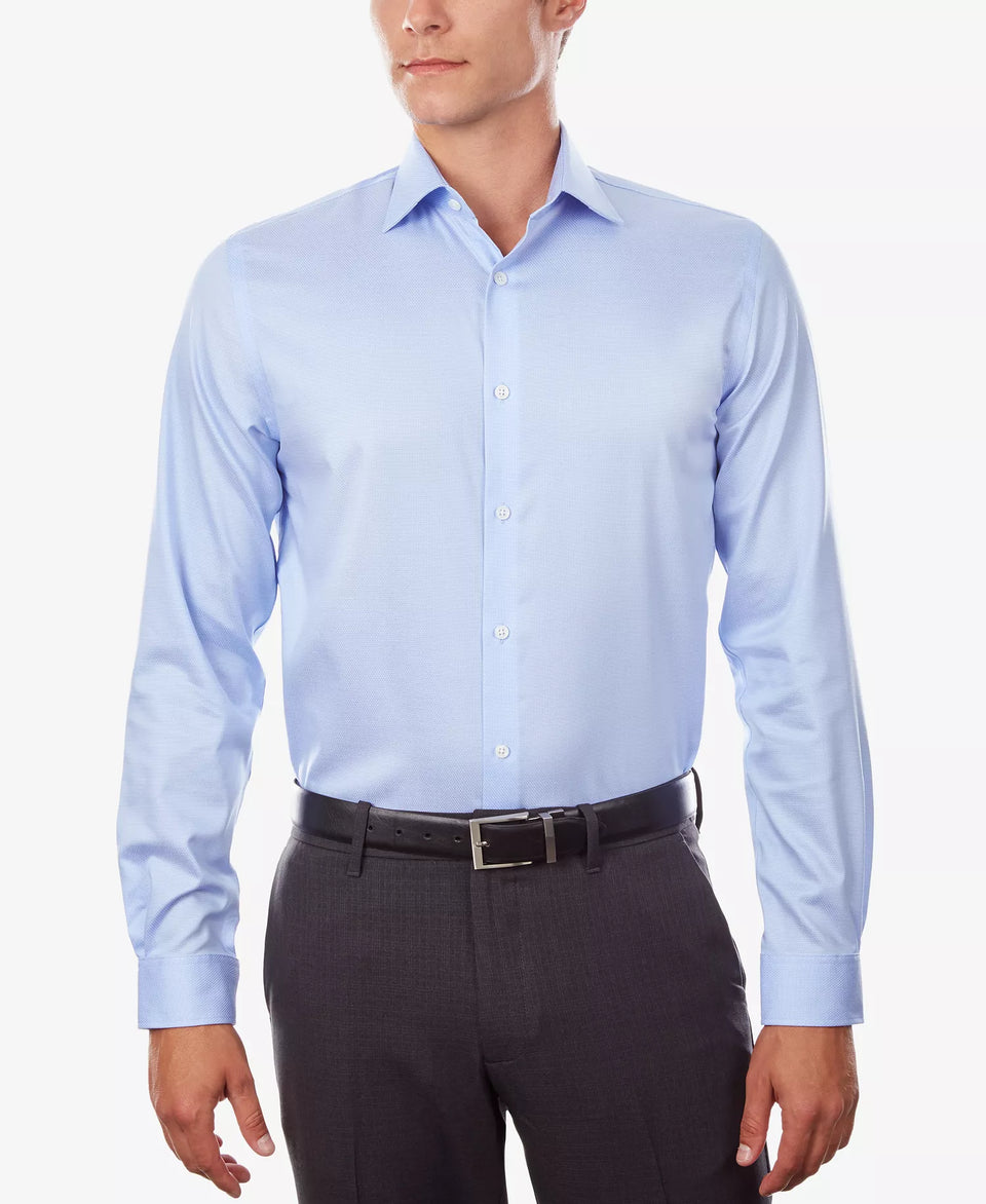 Man wearing a light blue dress shirt and dark pants on a white background