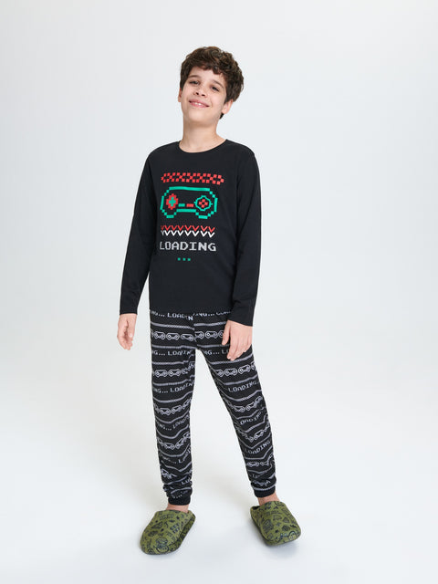 Child wearing a black sweater with a colorful design and patterned pants on a white background
