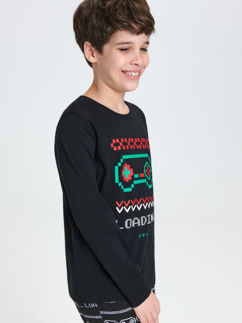 Child wearing a black long-sleeve shirt with colorful graphics on a light gray background