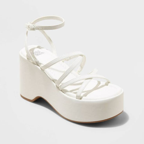 White platform sandal with strappy design on a light gray background
