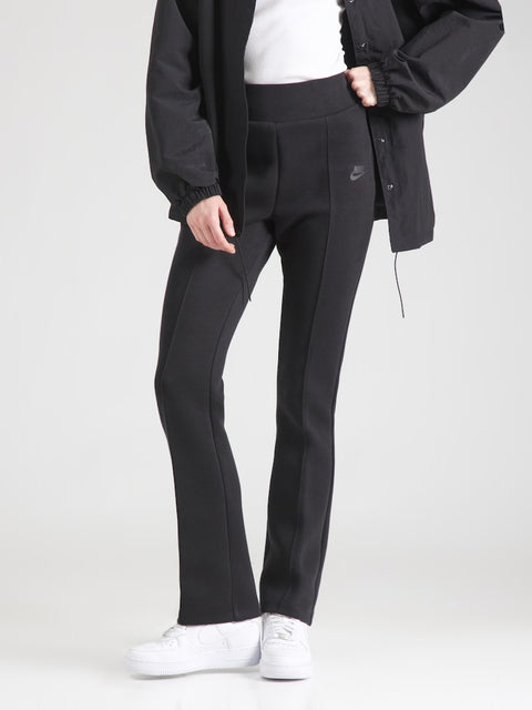 Person wearing black Nike pants on a white background