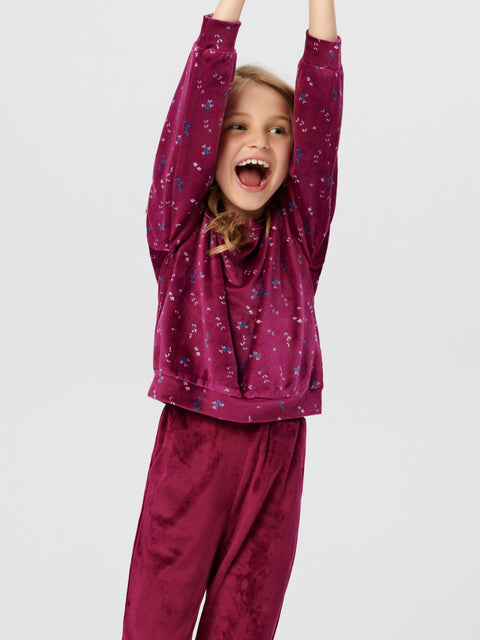 Child wearing a purple pajama set with a white background