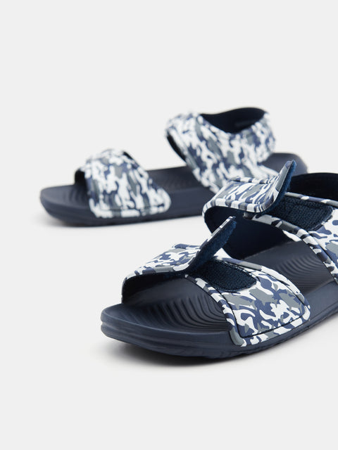 Pair of navy and white patterned sandals on a light gray background