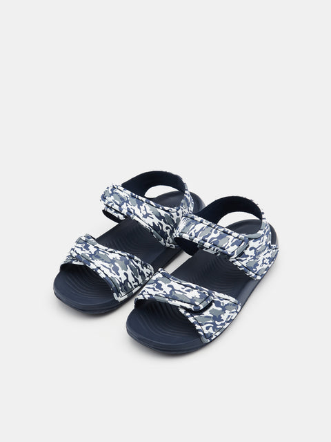 Pair of navy sandals with camouflage straps on a light gray background