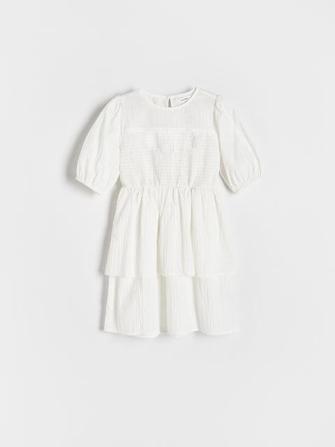 White dress with puff sleeves on a light gray background