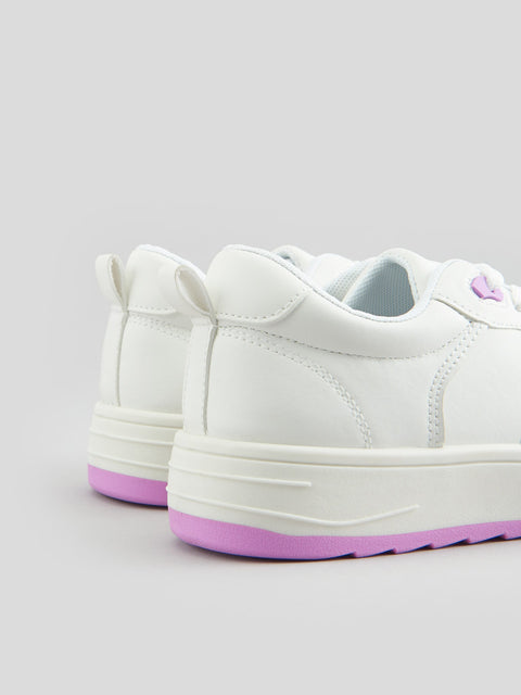 White sneakers with pink soles on a light gray background