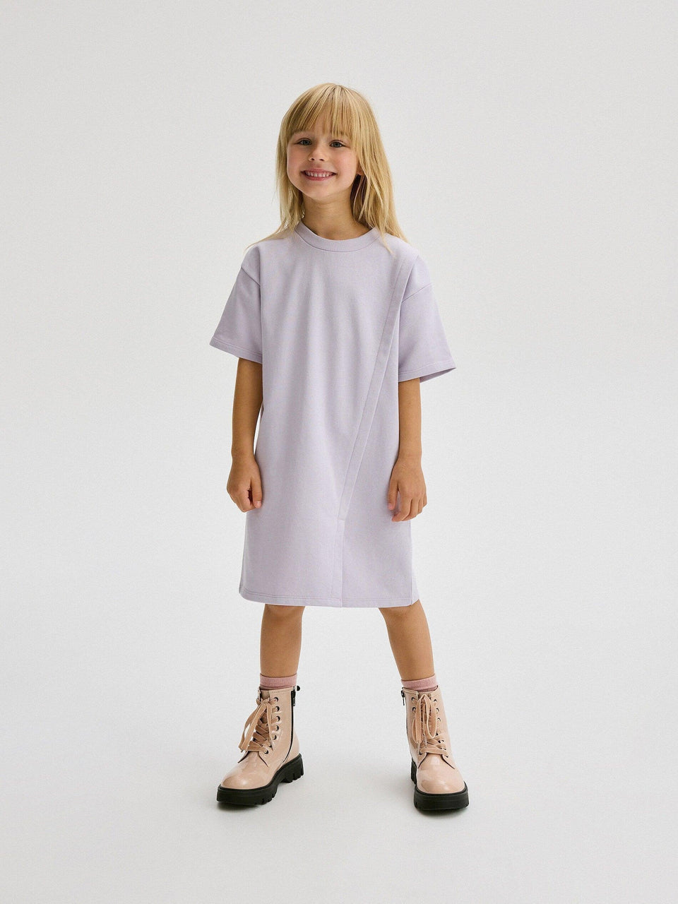 Young girl wearing a light purple dress on a white background