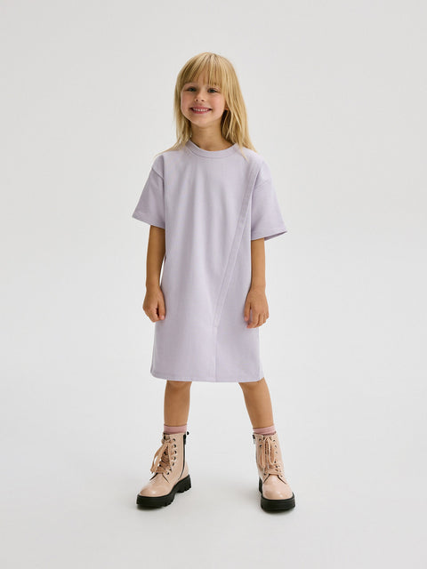 Young girl wearing a light purple dress on a white background