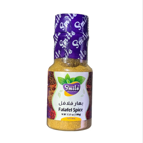 Bottle of smile Falafel Spice held by a hand with a blurred background