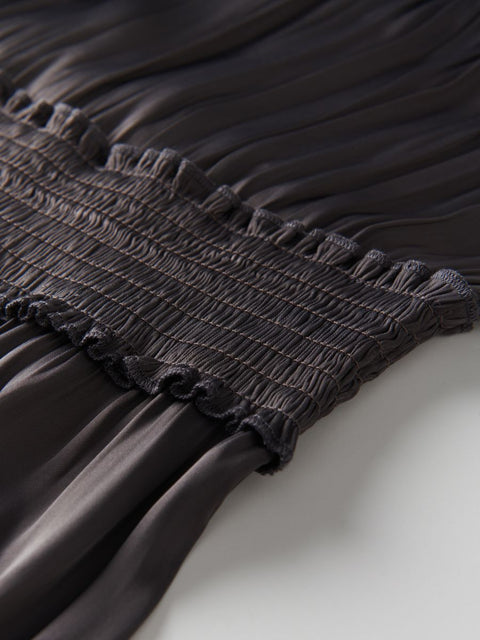 Close-up of a black pleated garment on a white background