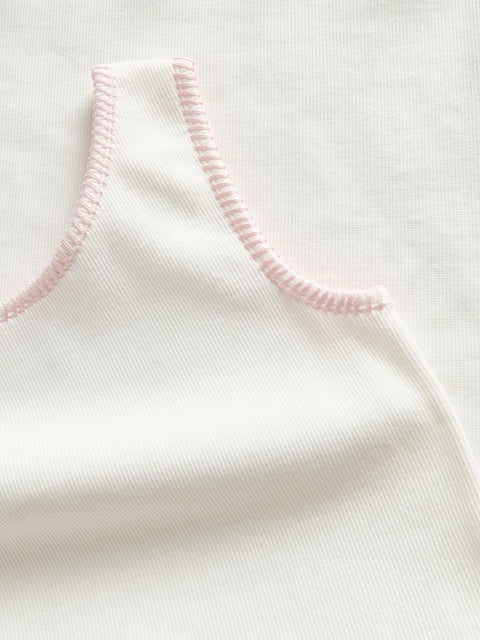Close-up of a white garment with pink stitching on a white background