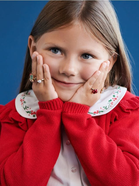 Young girl wearing red jewelry against a blue background