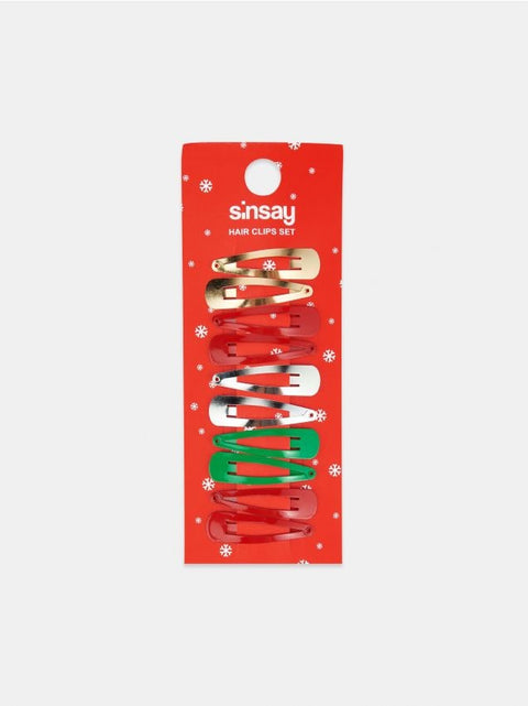 Set of hair clips in red, green, and gold packaging on a white background