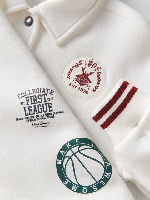 Close-up of a white shirt with logos and text on a light gray background