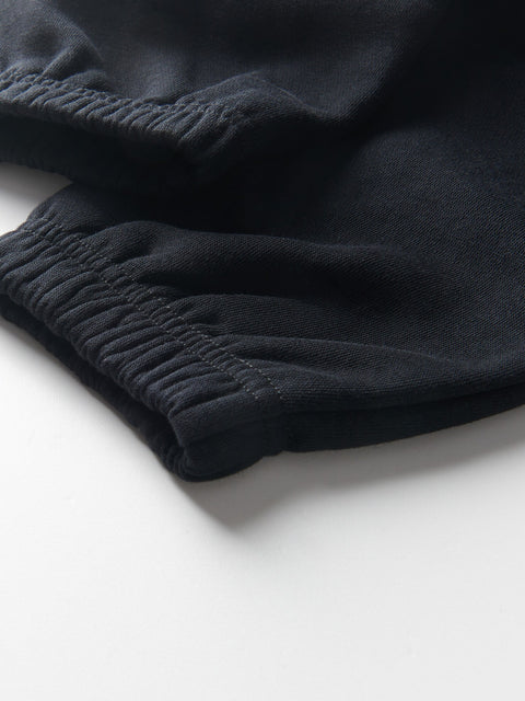 Close-up of black pants with a white background