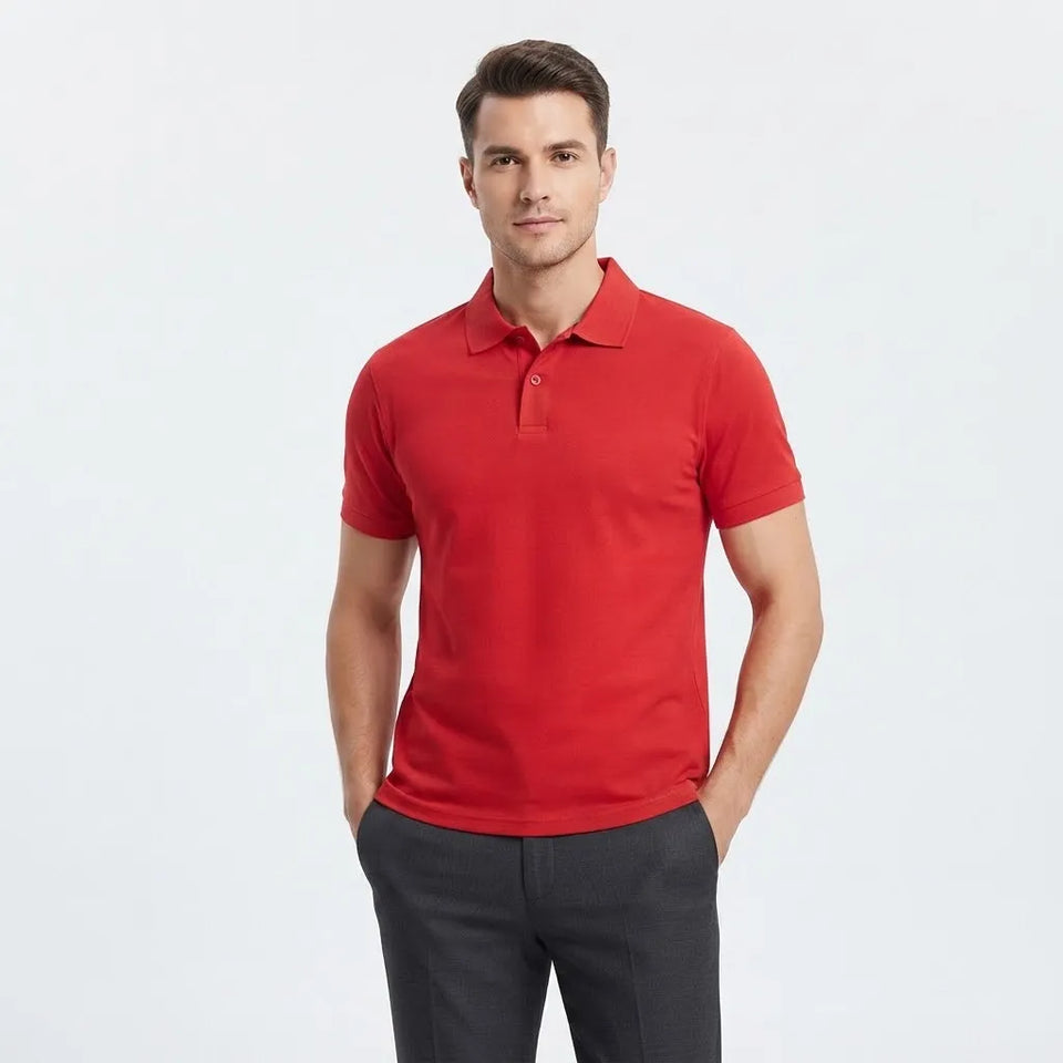A man wearing a bright red short-sleeve polo shirt and dark gray trousers, standing against a clean white studio background.